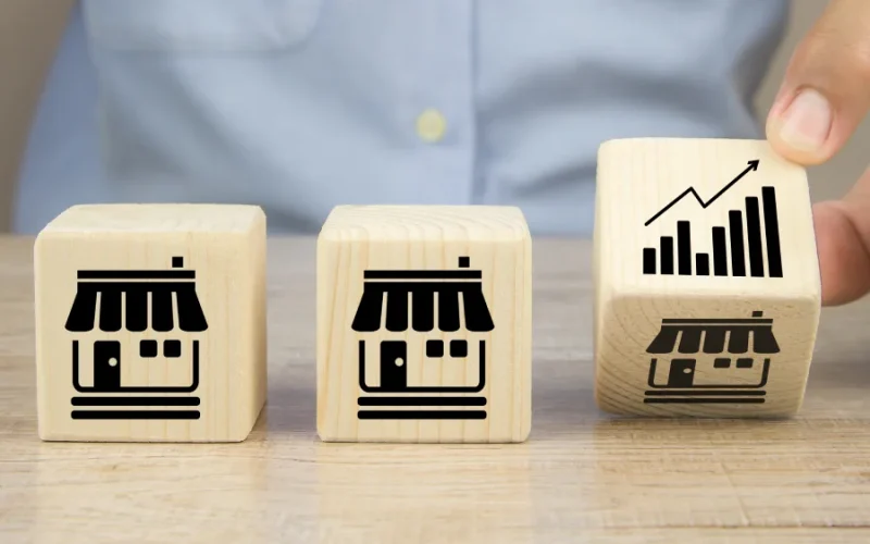 close-up-hand-choose-graph-icon-cube-wooden-toy-blocks-place-line-up-with-franchise-business-store-icon